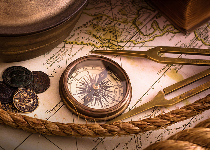 Vintage compass lies on an medieval map